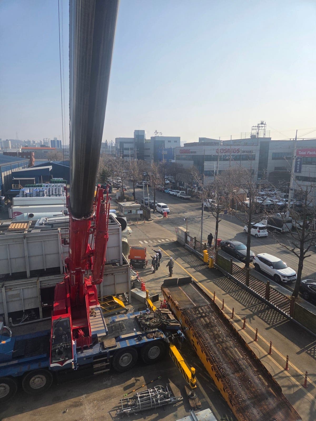 공단 도로변에서 자재 인양을 준비하는 대형 크레인